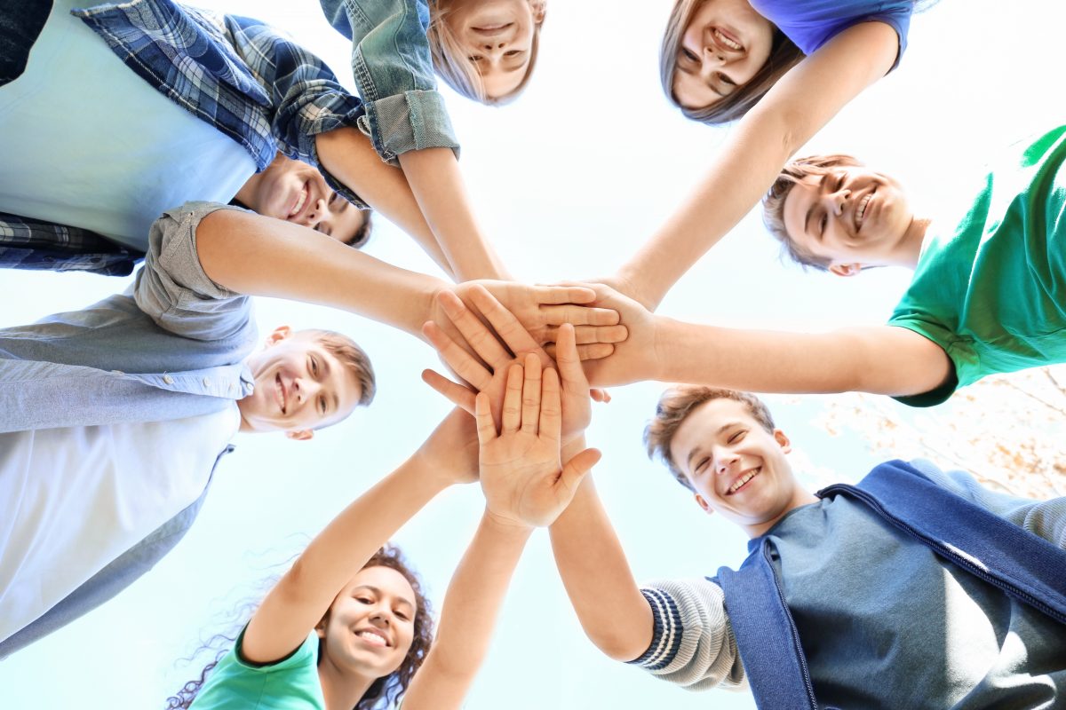 Bild einer Gruppe junger Menschen die ihre Hände vereint halten