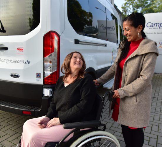 Auf dem Foto ist der neue Bus zu sehen, davor stehen die Erzieherin Ebby Stracke und Regina Carmen Bernhard, die im Rollstuhl sitzt.
